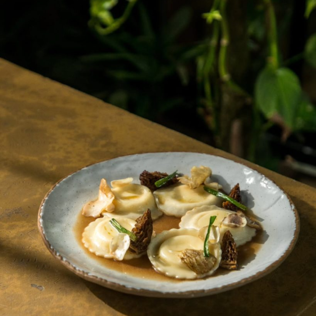 Chef Bhatia promotes using regional and hyperlocal ingredients. Featured here is parmesan ravioli, morel and pink oyster mushrooms, coffee mushroom broth